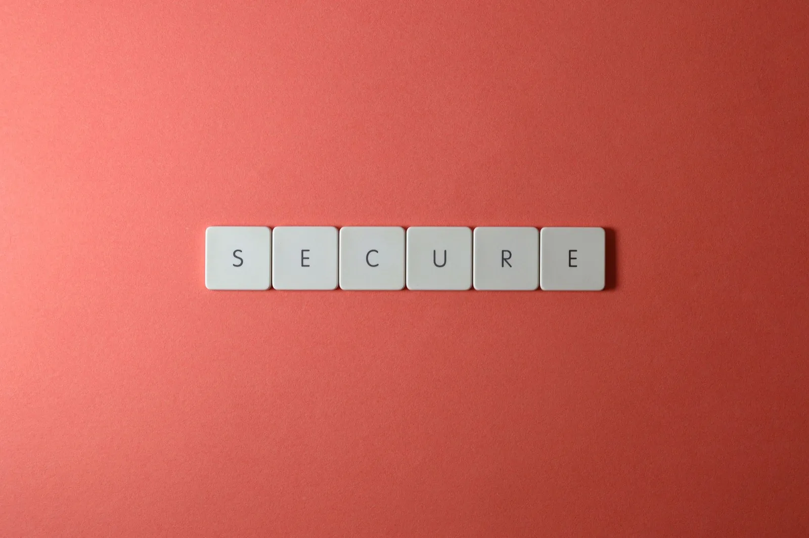 Best Application Security Tools in 2026 — A close-up of the word 'Secure' spelled out with tiles on a red surface, ideal for…