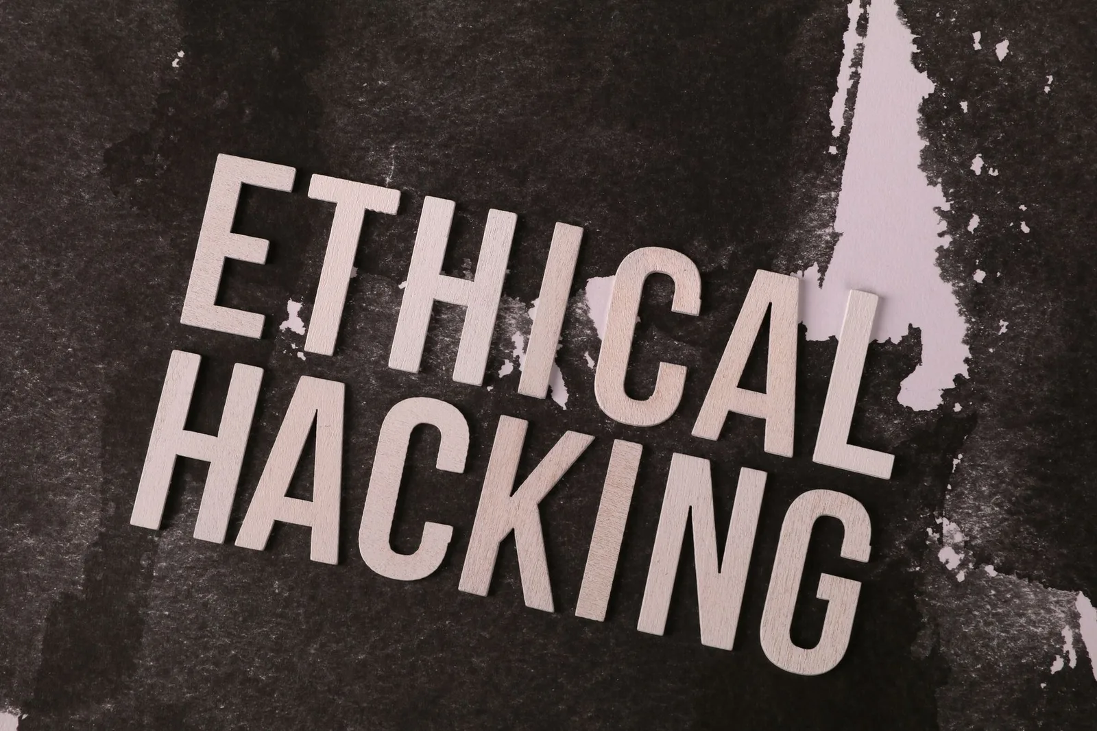 Best Attack Surface Tools in 2026 — Conceptual image showing the words 'Ethical Hacking' on a textured abstract background.