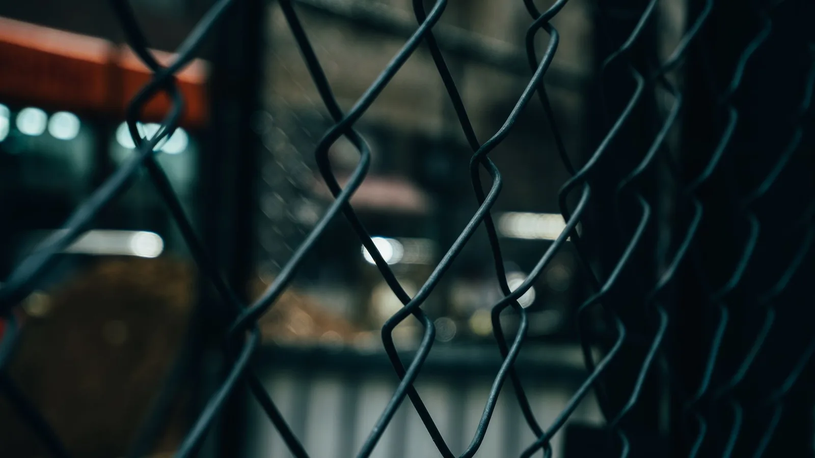 Best Endpoint Detection and Response Tools in 2026 — Close-up of a chain link fence with bokeh lights in the background, crea…