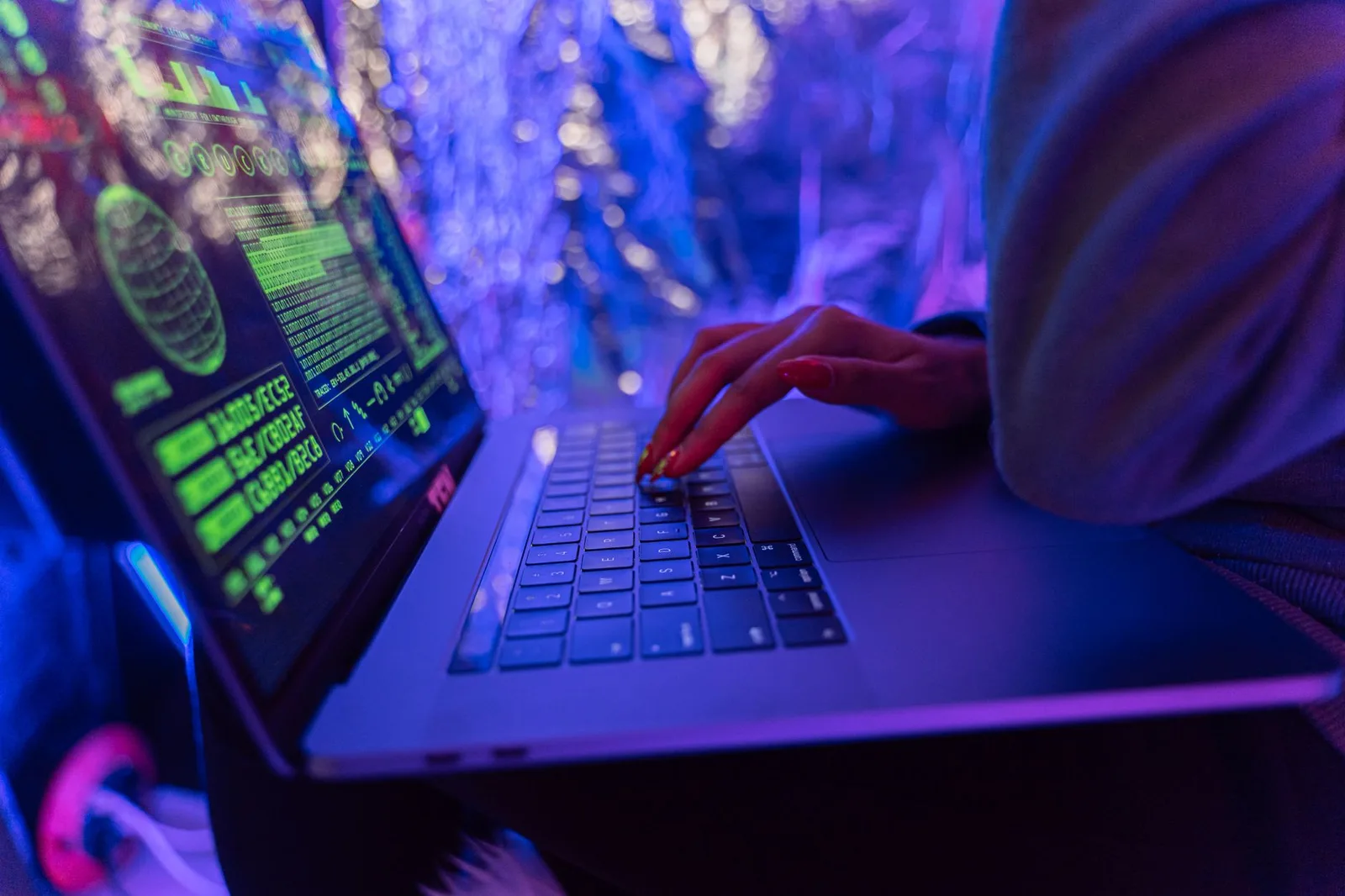 Best Digital Risk Protection Tools in 2026 — Close-up of hands typing on a laptop displaying cybersecurity graphics, illumina…