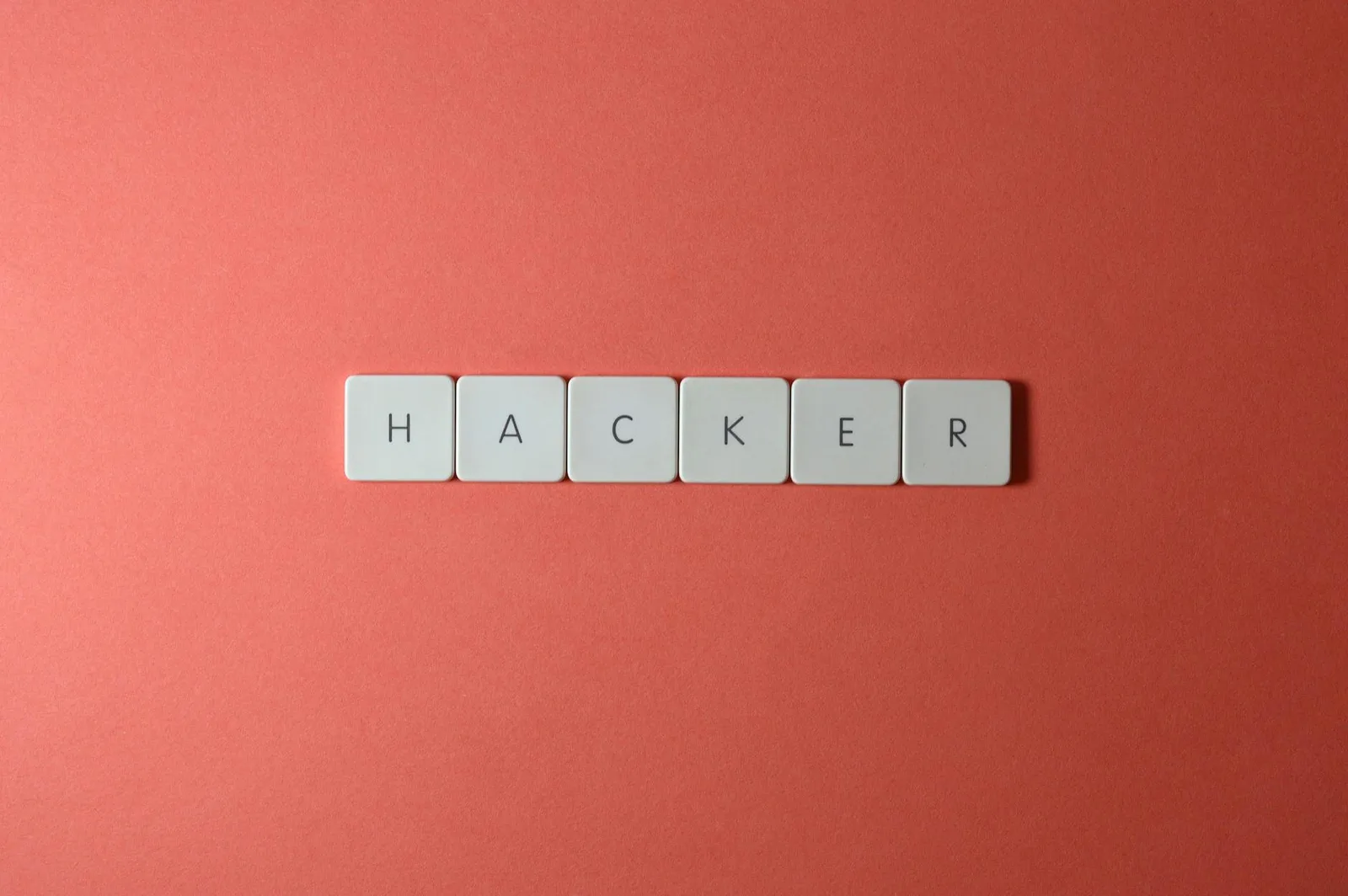 Best Email Security Platforms Tools in 2026: Top 7 Compared — Close-up of the word 'HACKER' made with letter tiles on a red b…