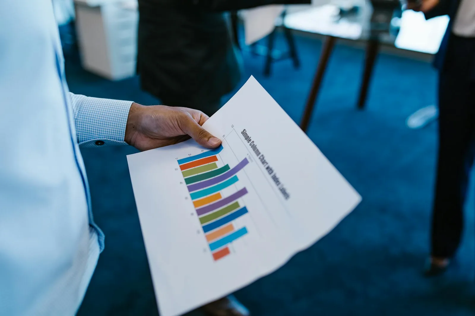 Protect Maturity Assessment: Where Most Programs Fall Short — Business personnel reviewing a colorful bar chart report in an…